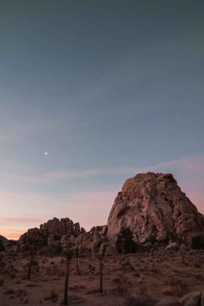 Early sunrise against a large rock formation