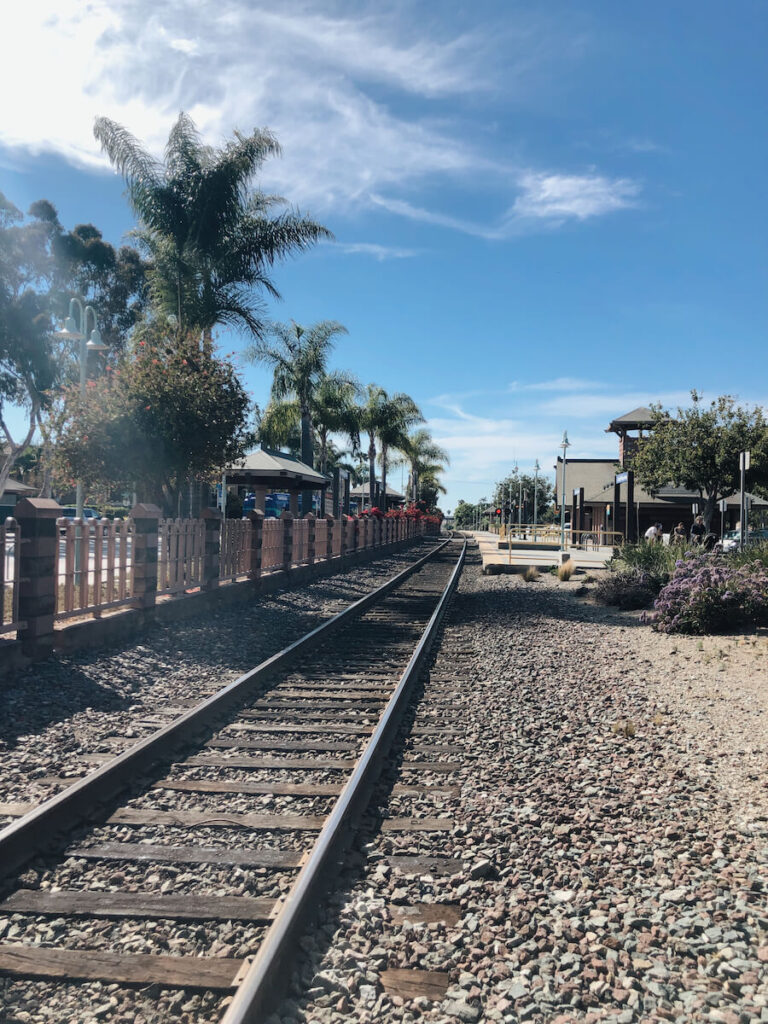 Empty Train Tracks in Carlsbad. There are palm trees on the left side of the tracks.