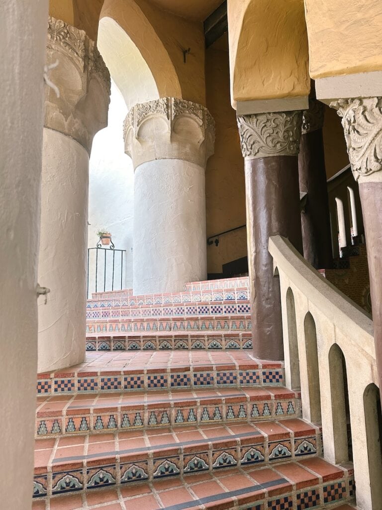 A curved outdoor staircase featuring detailed tiles and large columns at the Santa Barbara County Courthouse