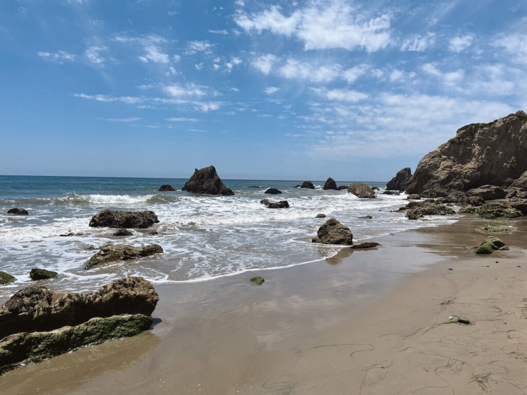 Waves crashing into various sized rocks on the beach at El Matador Beach