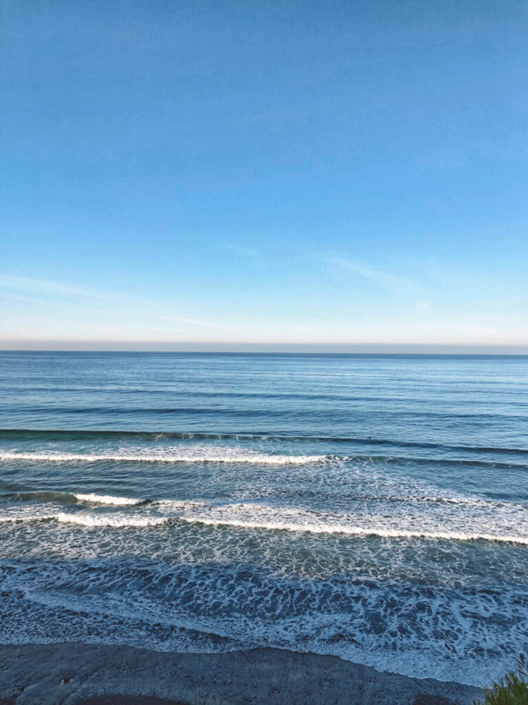 A straight-on view of the ocean, with waves rolling in towards the sand.