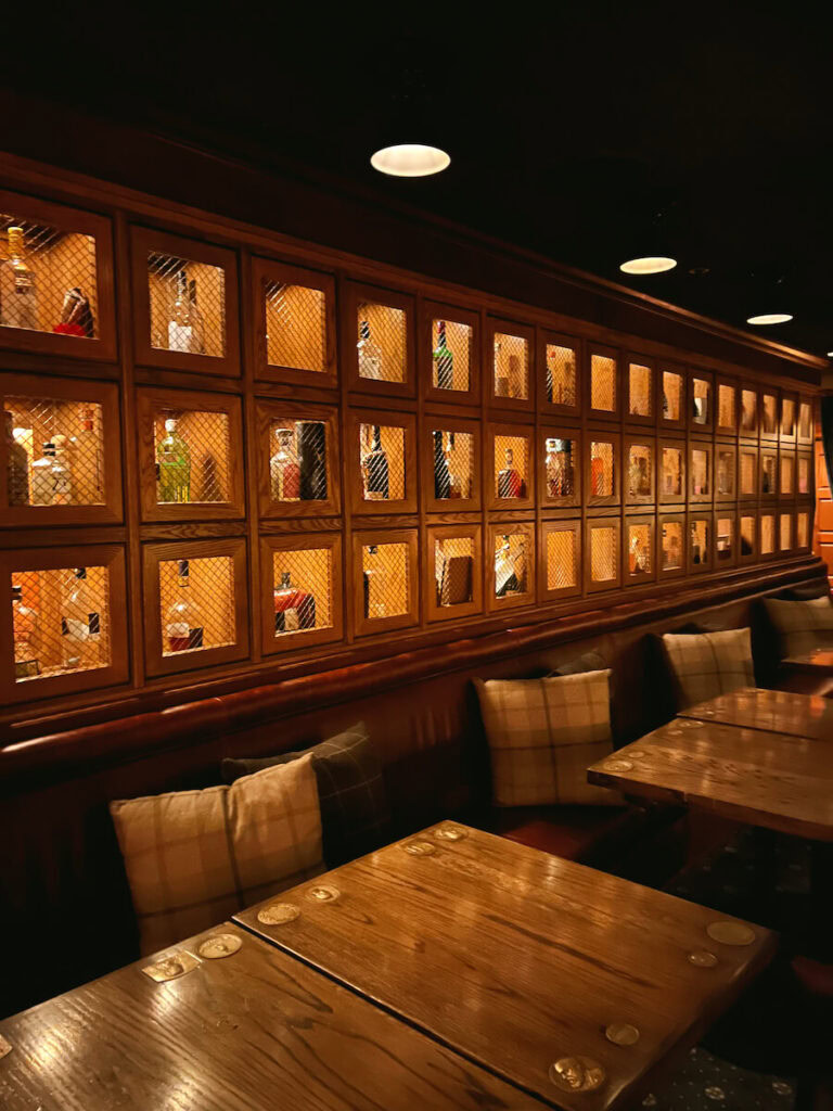 Tables at Bud's with a lit case of different spirits behind them