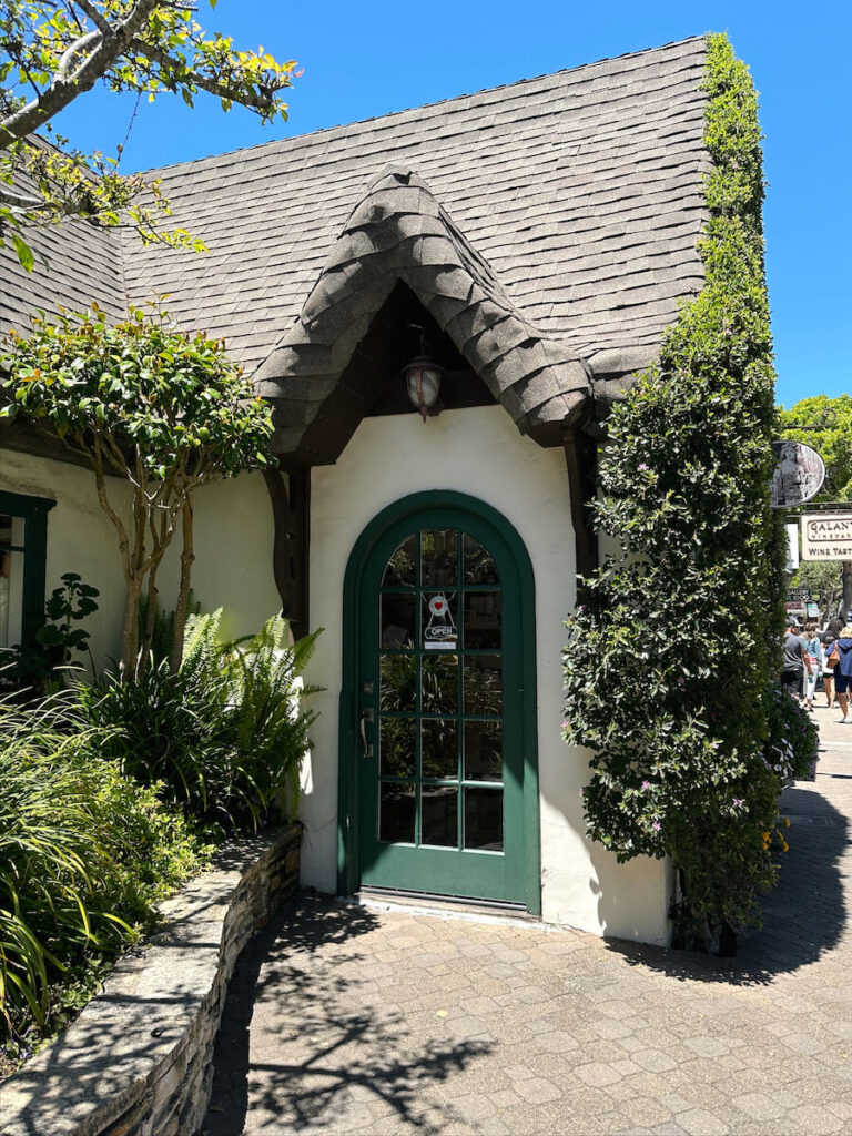 A cottage-style building with a green arched door in Carmel.