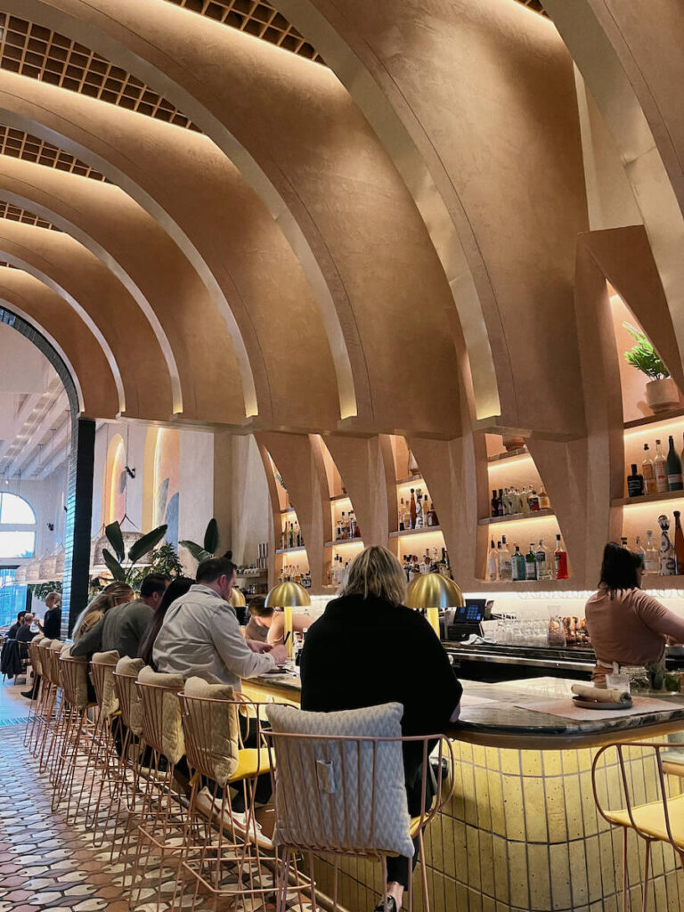 The bar at Planta, with curved wood beams connecting up to the ceiling