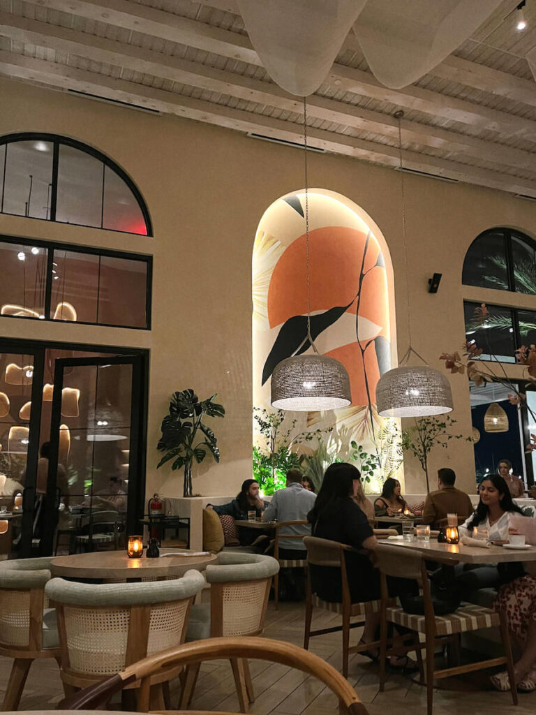 Tables in front of an abstract mural on the wall in the interior of Planta