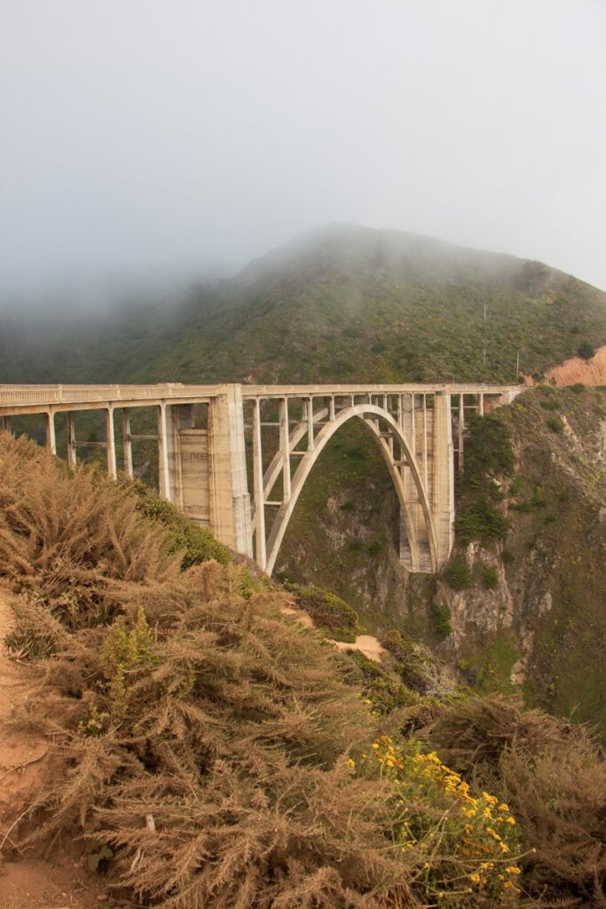 The front side of Bixby Bridge, with fog rolling in right above it