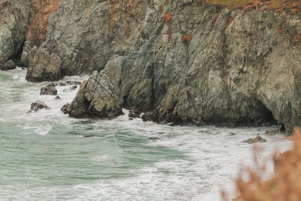 A closeup look at small waves crashing into rocks at Soberanes Point