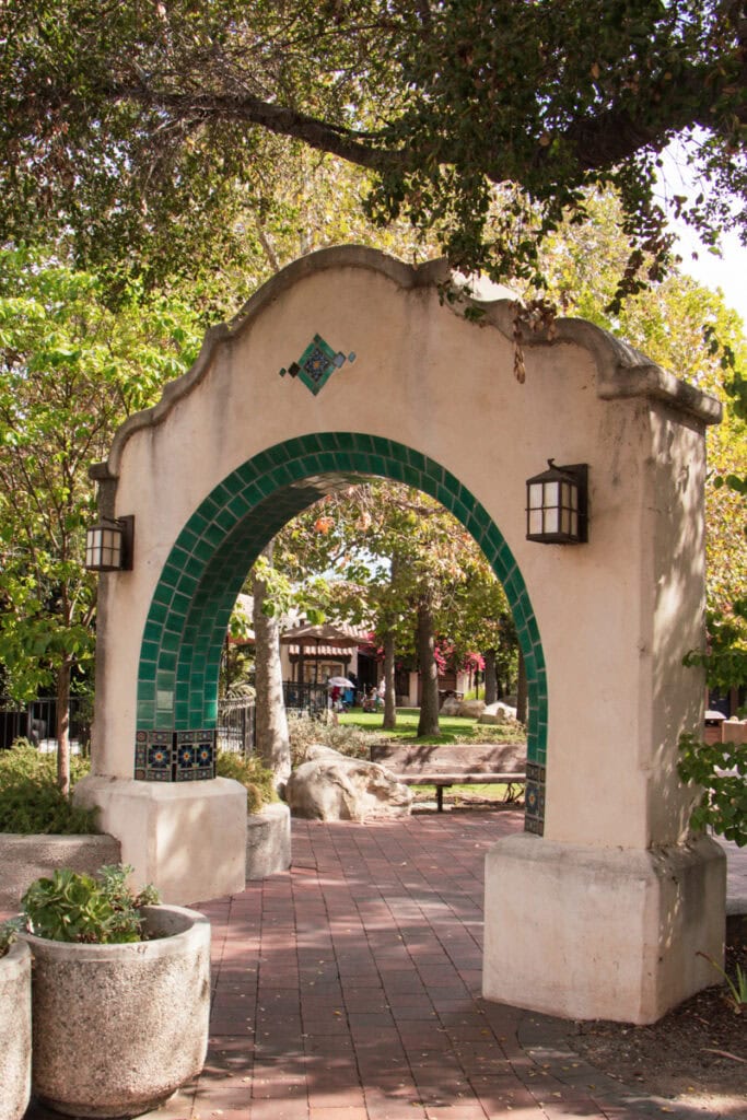 A stucco archway with green tiling in the center oj Ojai. 