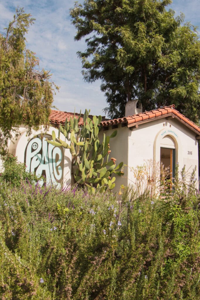 A building in Ojai with an arched window with the word "Peace" painted on it in blue. 