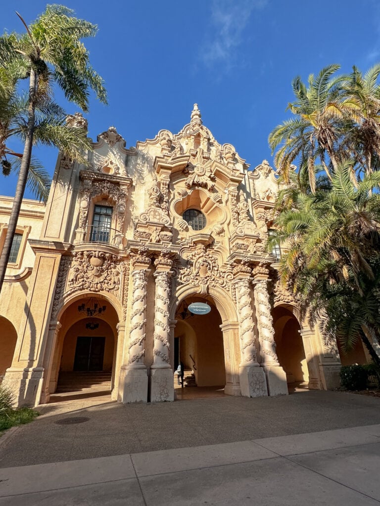 An intricately designed building in Balboa Park, surrounded by palm trees