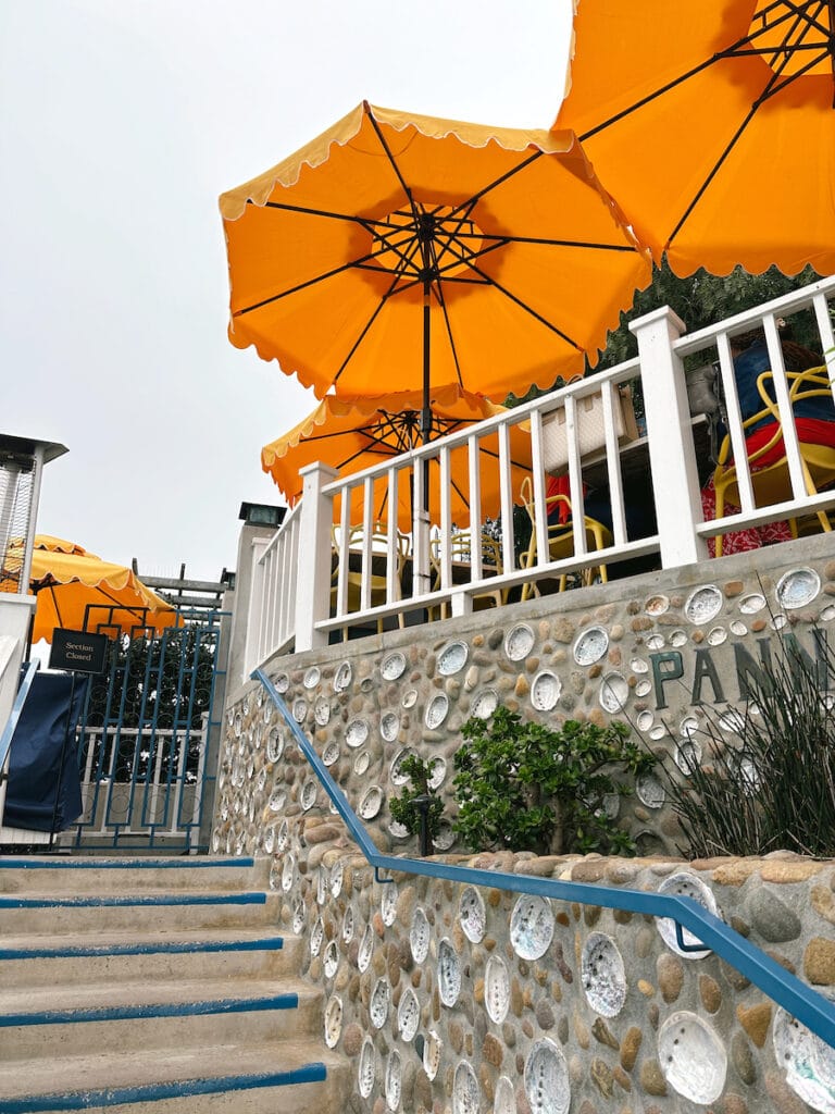 Stairs leading up to the entrance of Brockton Villa. There are bright orange umbrellas on the patio.