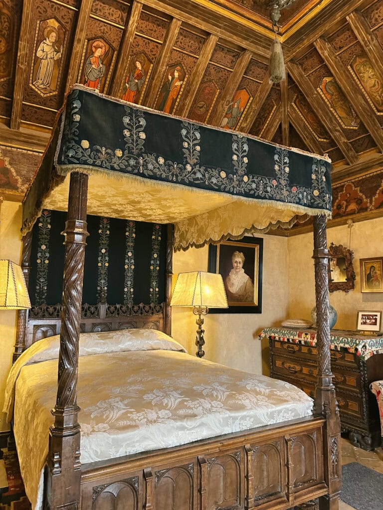 A bedroom in Hearst Castle featuring a four post bed and an intricate wooden ceiling