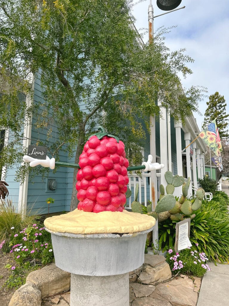 A sculpture of an oversize Olalliberry on top of a pie in front of Linn's Cafe