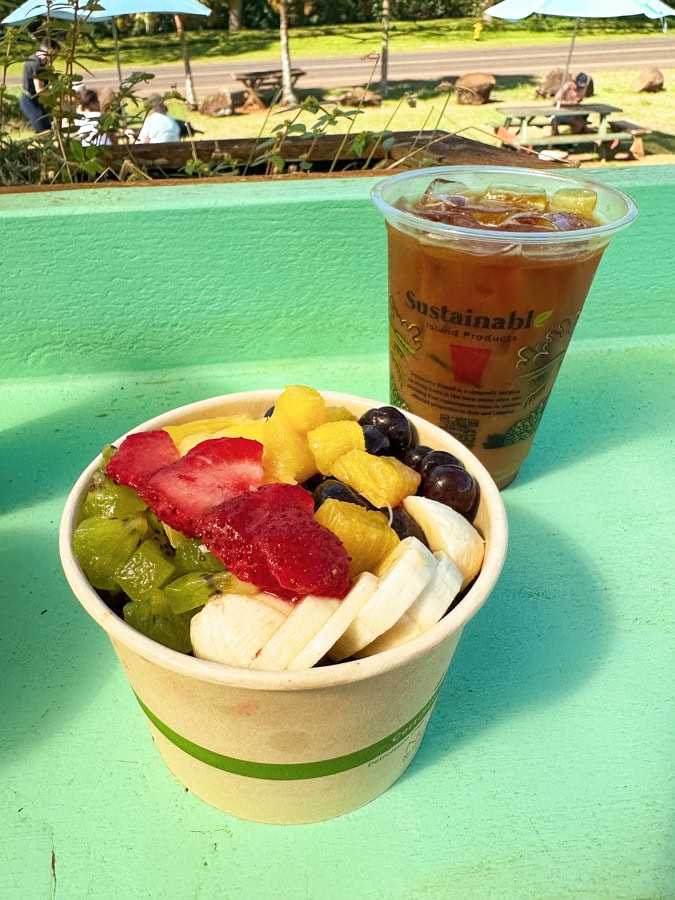 An acai bowl next to a cup of iced coffee