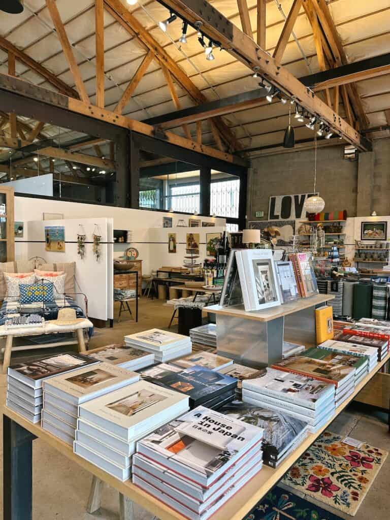 The interior of the store SoLo in Solana Beach. There are vaulted ceilings, and there is a table with a variety of coffee table books for sale.