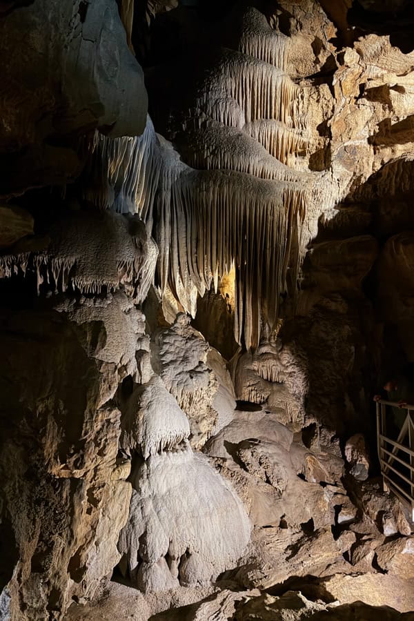 The interior of one of the rooms on the Crystal Cave tour in Sequoia National Park. There are crystal formations on the ground, and stalactites coming down from the ceiling.