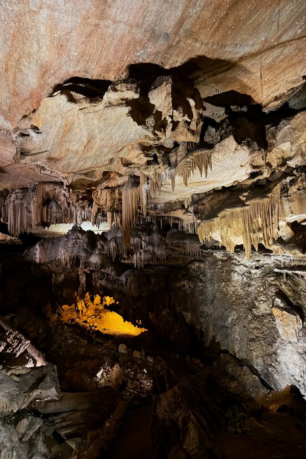 The interior of Crystal Cave in Sequoia National Park. There is a marble ceiling and stalactites coming down from the ceiling.